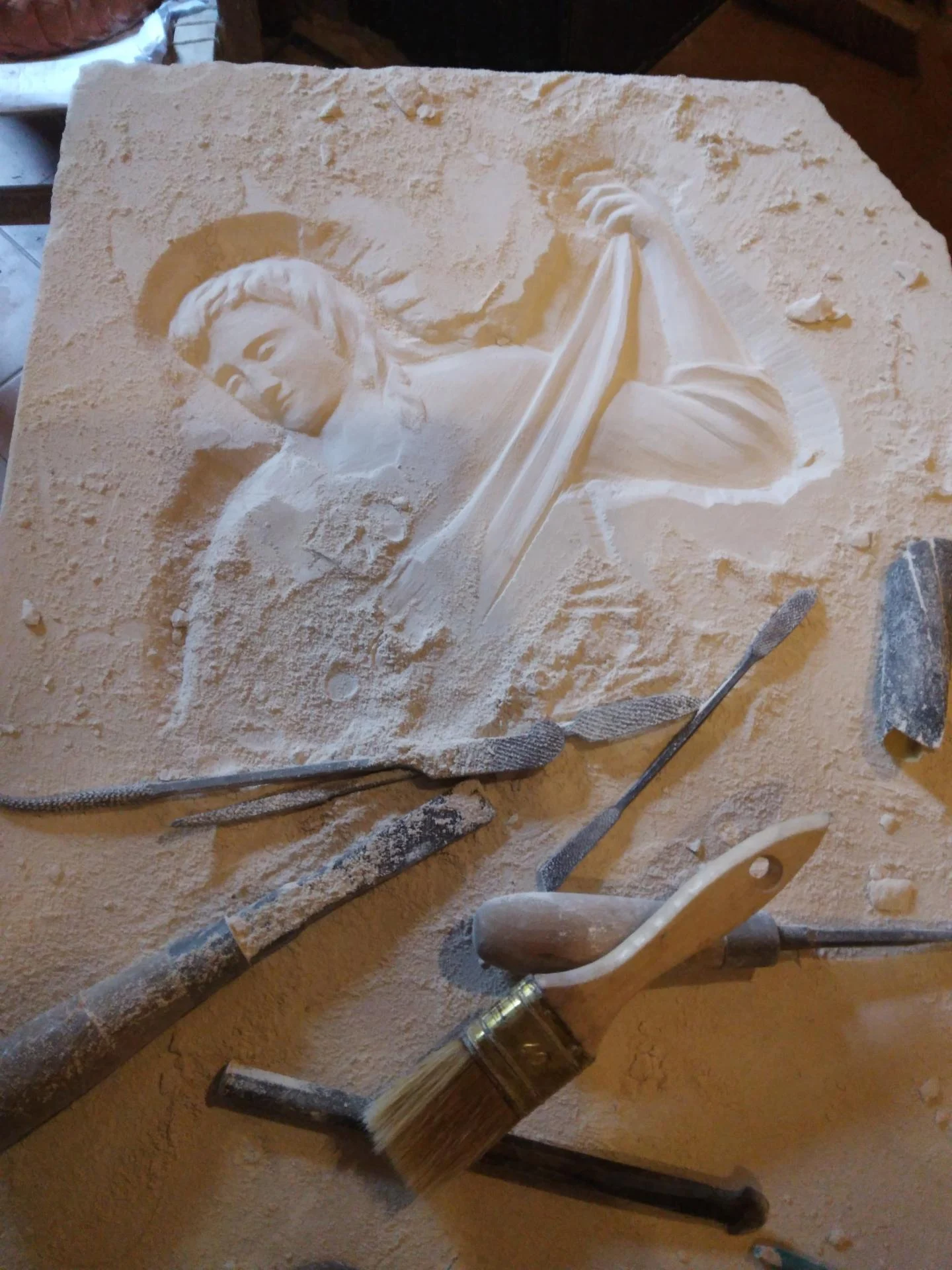 Sculpteur taillant un ange en pierre pour autel d'église — demi-relief taille directe, mobilier liturgique sur mesure