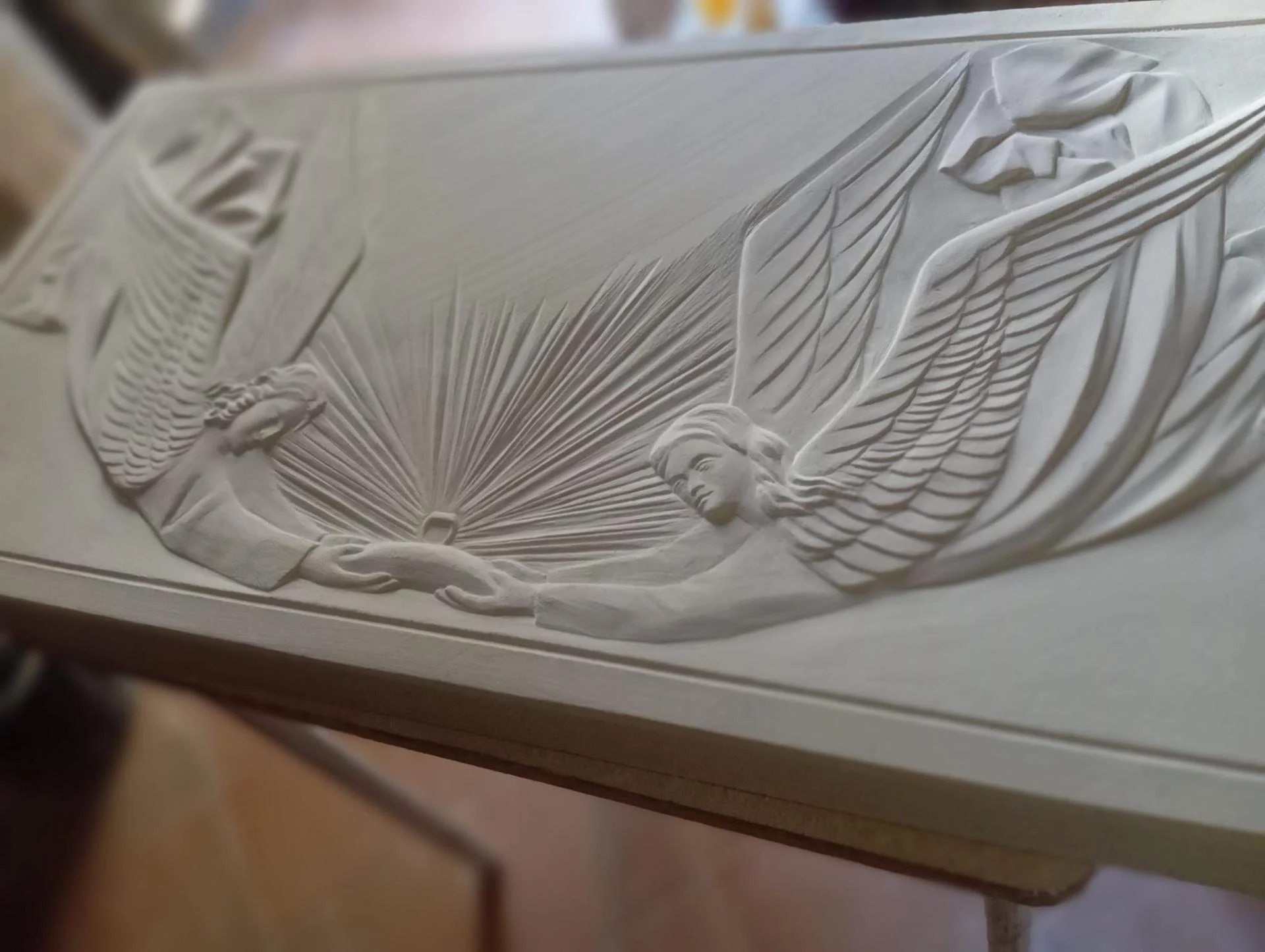 Gros plan sur l'ange aux ailes déployées sculpté en taille directe — autel en pierre calcaire de l'église Sainte-Jeanne-d'Arc de Rennes, bas-relief De par le Roy du Ciel, mobilier liturgique Jean-Joseph Chevalier