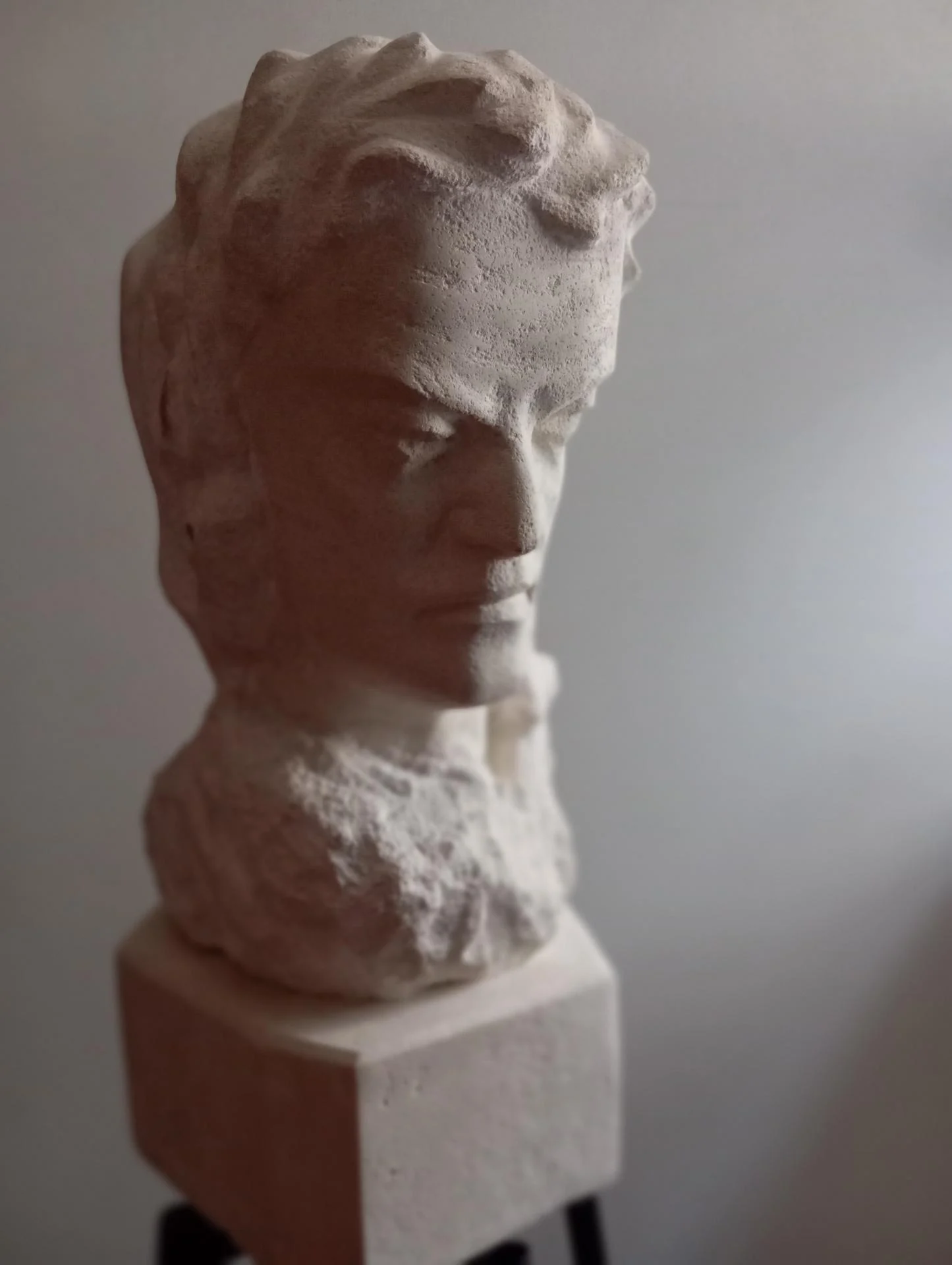 Le révolutionnaire, de face — le regard baissé, fermé, de celui qui restera en vie mais est mort intérieurement. Buste bicéphale en pierre calcaire naturelle, taille directe, 60 cm, 2025. Sculpteur d'art sacré Jean-Joseph Chevalier (Brignoles, Var, Provence).