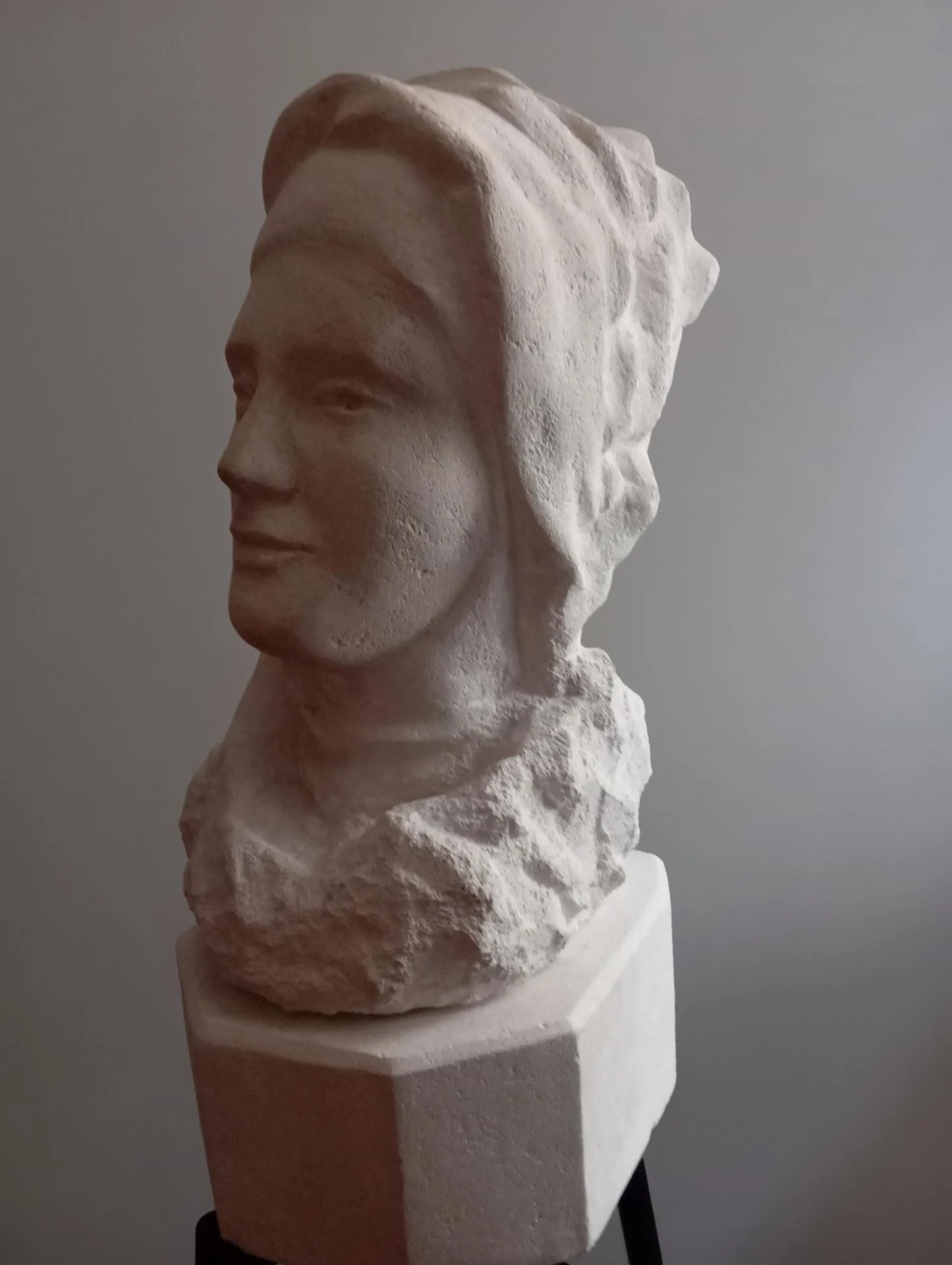 La carmélite en trois-quarts — le sourire paisible de celle qui va mourir pour Vivre : l'Amour. Buste bicéphale en pierre calcaire naturelle, taille directe, 60 cm, 2025. Sculpteur d'art sacré Jean-Joseph Chevalier (Brignoles, Var, Provence).