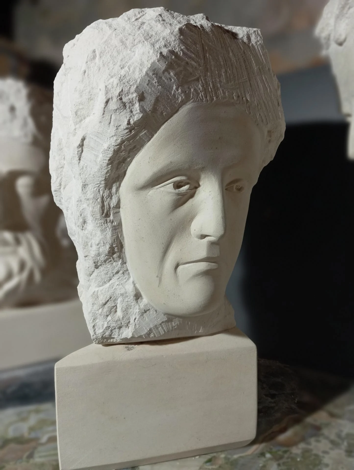 Le jeune homme riche, en trois-quarts — le regard sombre et baissé, la bouche fermée : la tristesse de celui qui s'en alla, car il avait de grands biens. Non finito en pierre naturelle, taille directe, 50 cm, 2025. Sculpteur d'art sacré Jean-Joseph Chevalier (Brignoles, Var, Provence).