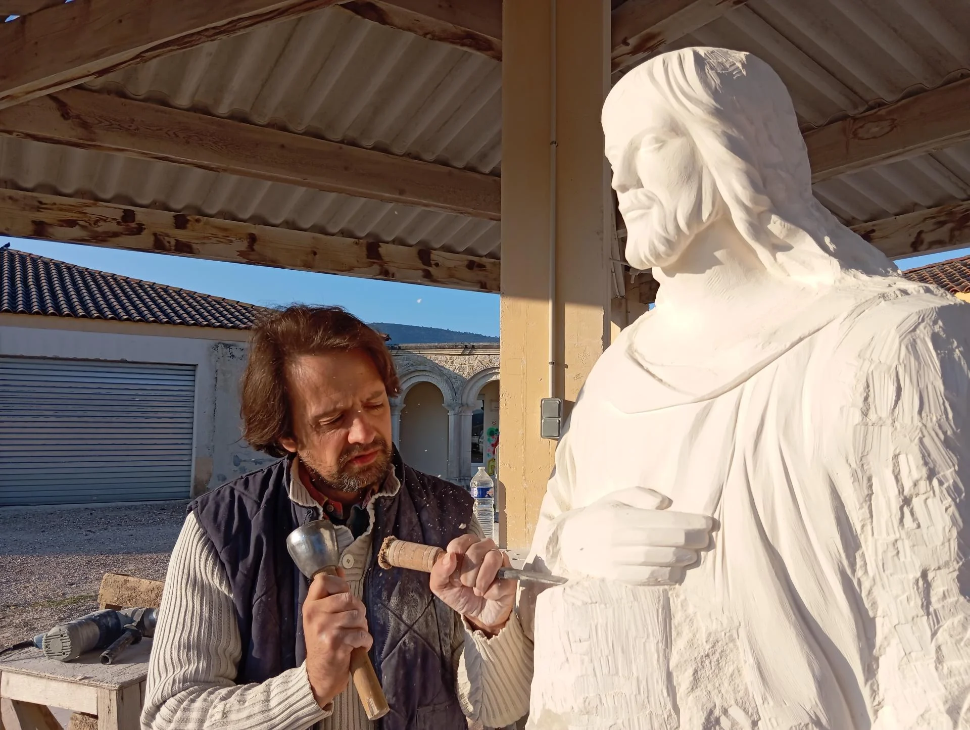 Avancement de la sculpture au ciseau et à la massette — taille directe du Christ charpentier en pierre naturelle calcaire — Jean-Joseph Chevalier sculpteur