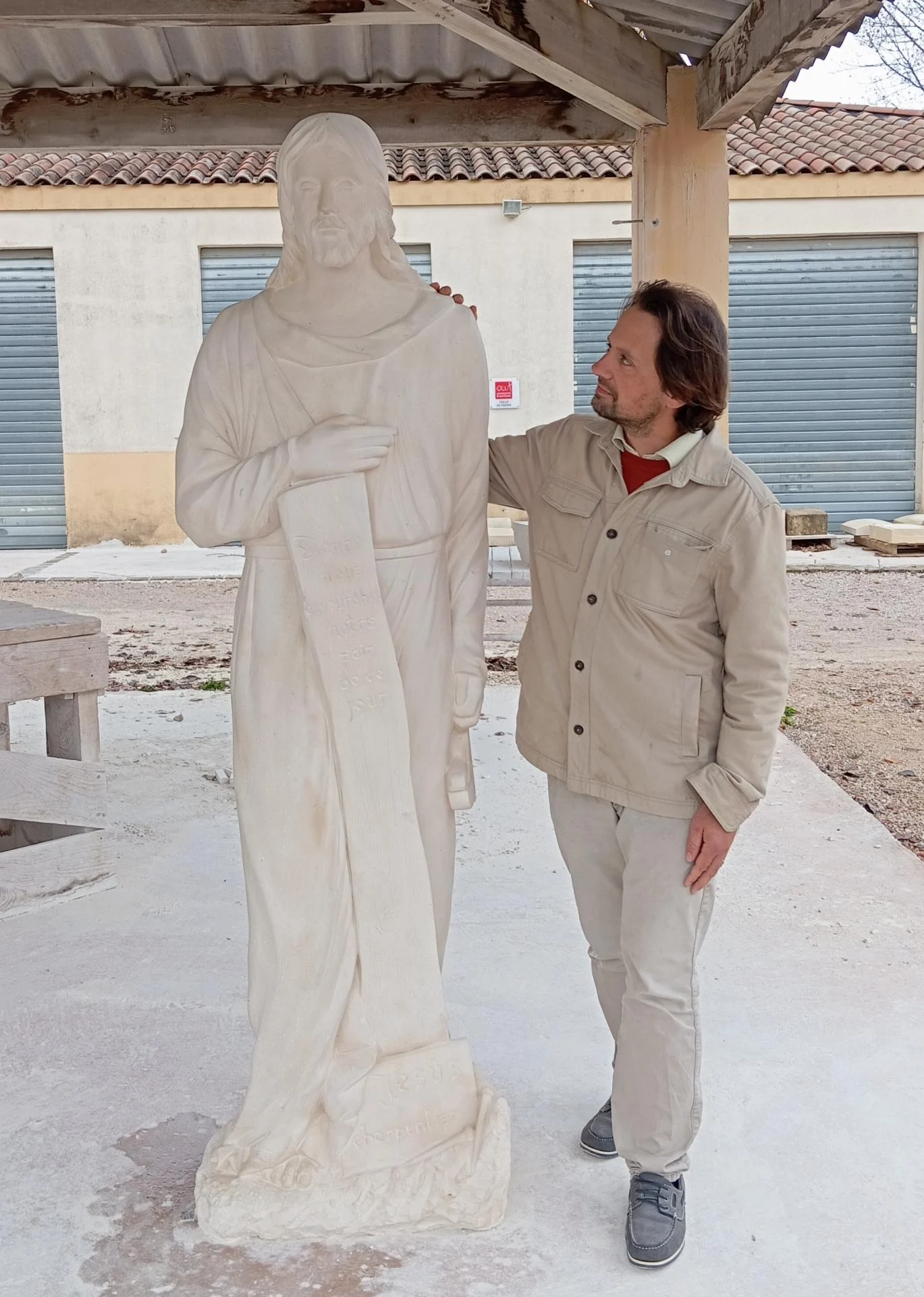 Le sculpteur Jean-Joseph Chevalier auprès du Christ charpentier achevé — pierre naturelle calcaire 200 cm