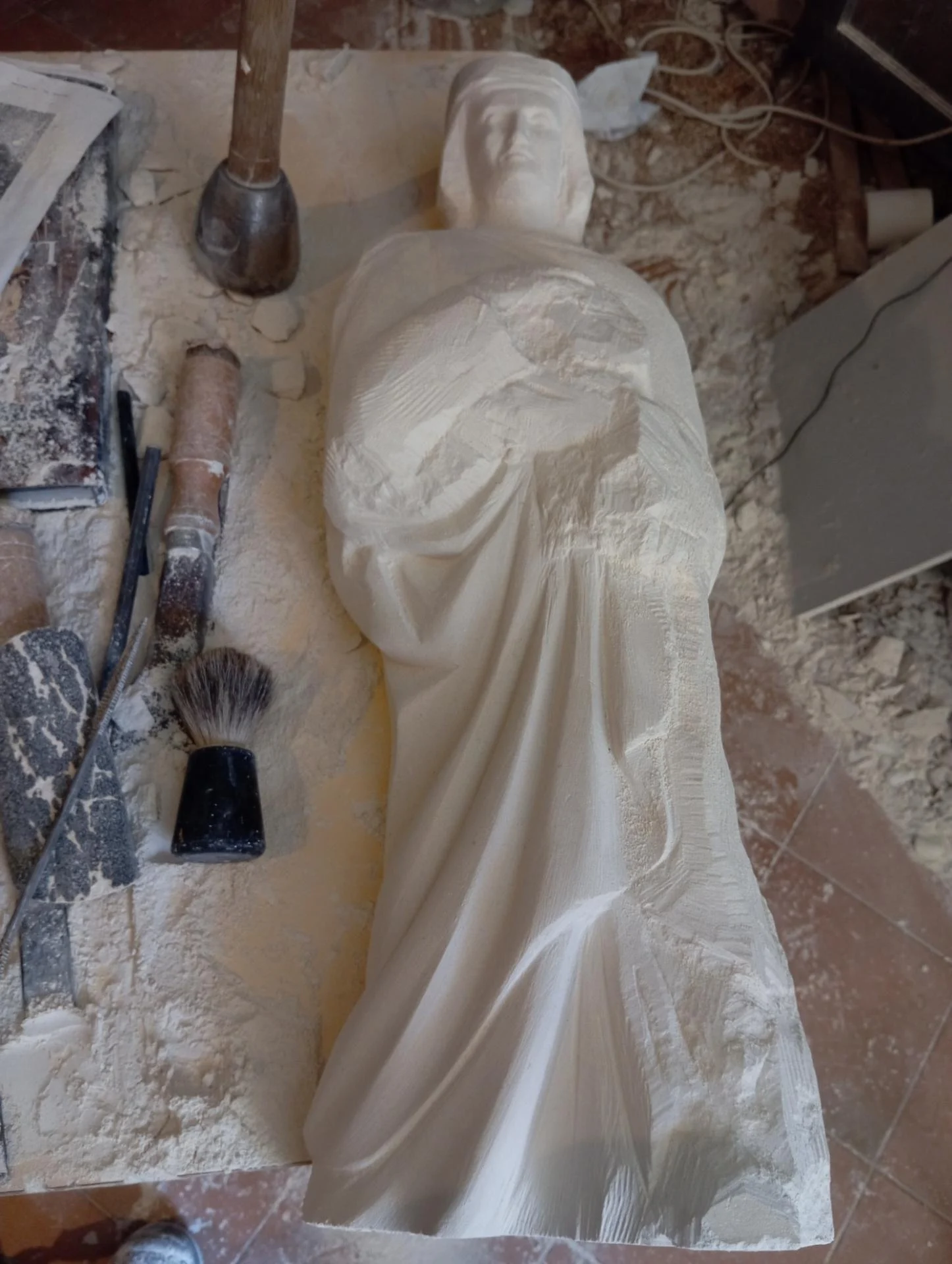 Vue VIII/VIII — La statue de saint Louis en cours de taille directe à l'atelier, corps et manteau. Pierre calcaire. Jean-Joseph Chevalier, sculpteur d'art sacré.