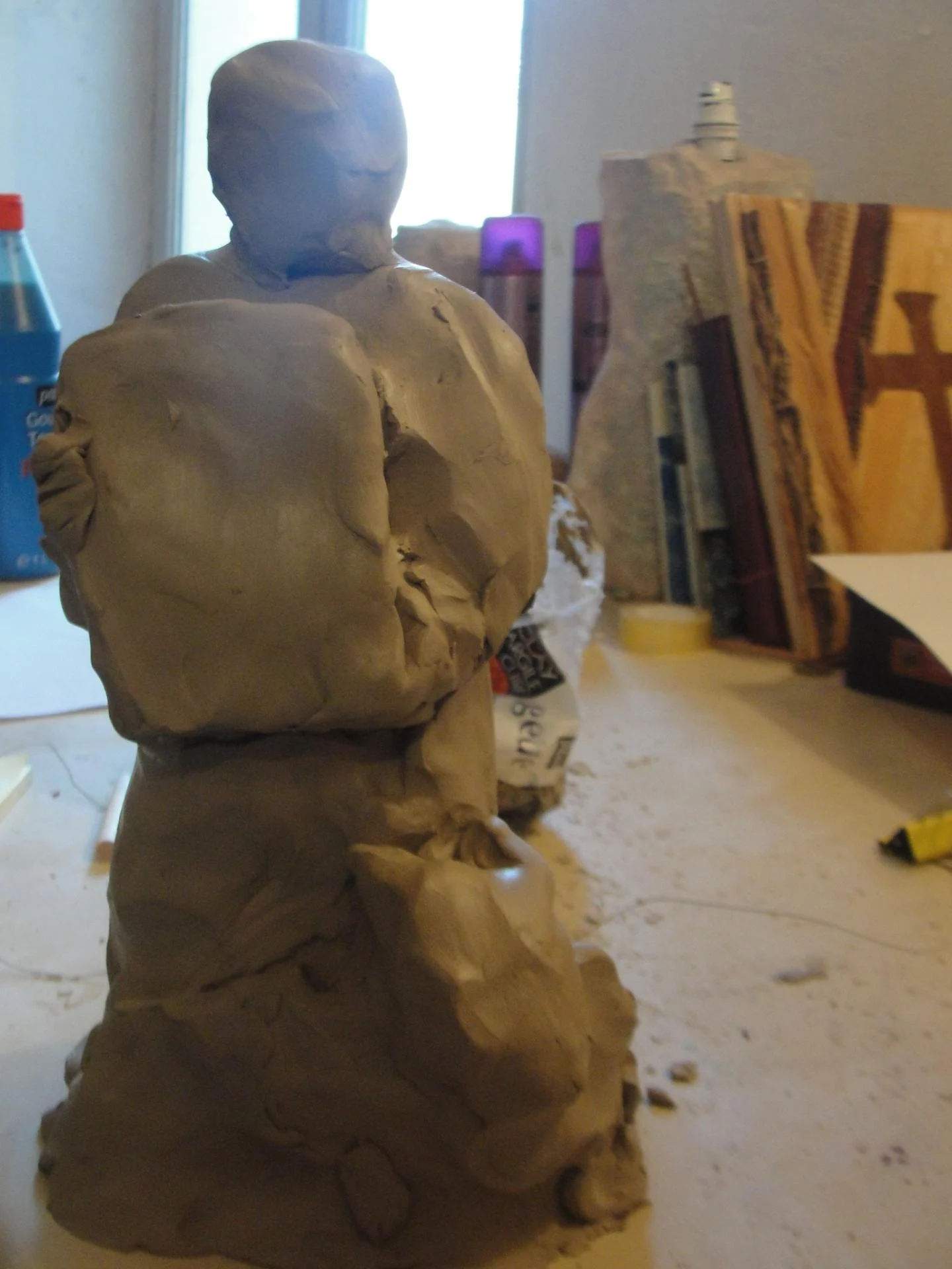 L'étude en argile de la statue Saint Luc — la maquette préparatoire modelée en terre dans l'atelier, figure tenant l'icône contre elle, avant le passage à la pierre. La pensée du sculpteur modelée du bout des doigts. Étape préparatoire de l'art sacré — abbaye de Lagrasse 2016 — Jean-Joseph Chevalier.