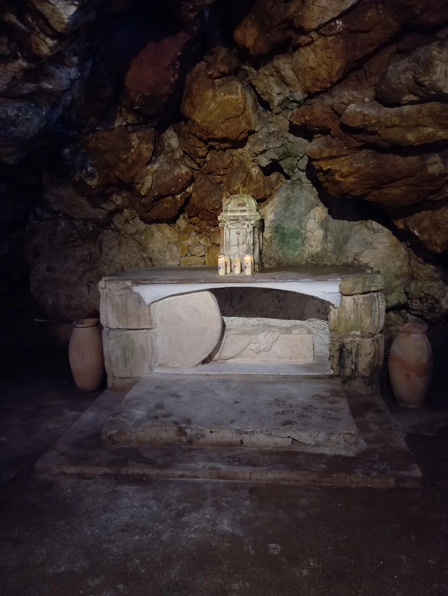 Le Tombeau du Christ vide — la pierre roulée, le suaire et le linge sur la banquette funéraire, sculptés en taille directe dans la grotte du sanctuaire de la Sainte-Baume par Jean-Joseph Chevalier, 2026