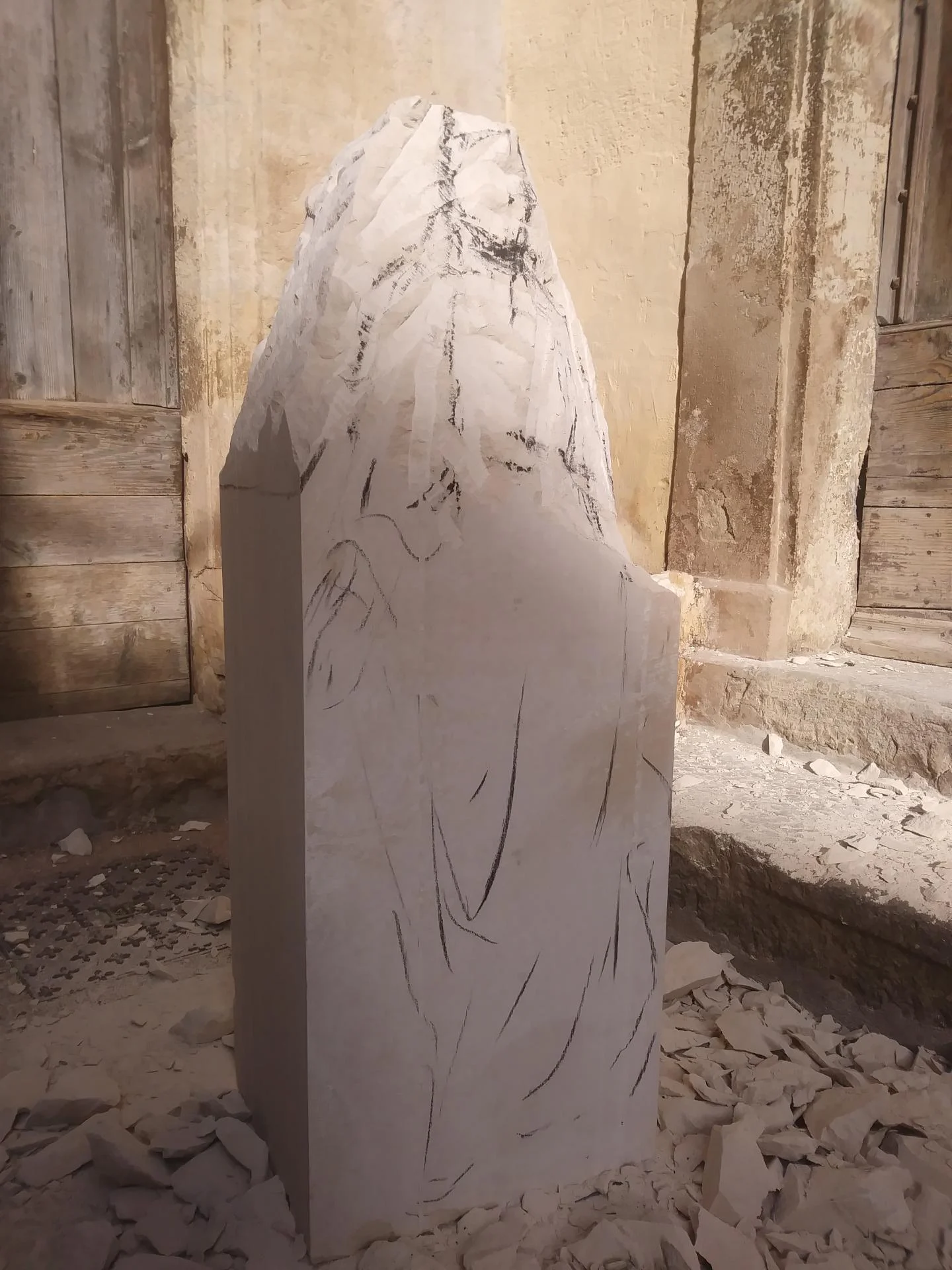 Vierge Immaculée non finito — dessin tracé au crayon sur le bloc de pierre calcaire brut, silhouette de la Vierge esquissée avant la taille directe — atelier extérieur école primaire Toulon — Jean-Joseph Chevalier sculpteur