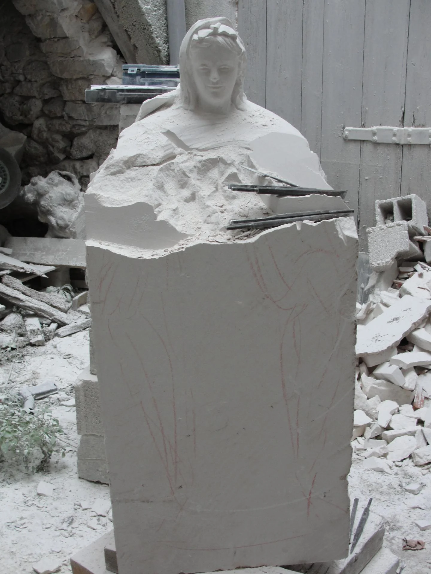 Vierge Immaculée sculpture vierge marie pierre calcaire 85 cm — en atelier taille en cours figure émerge bloc pierre brute — statue notre-dame commande coin prière Lyon — Jean-Joseph Chevalier sculpteur